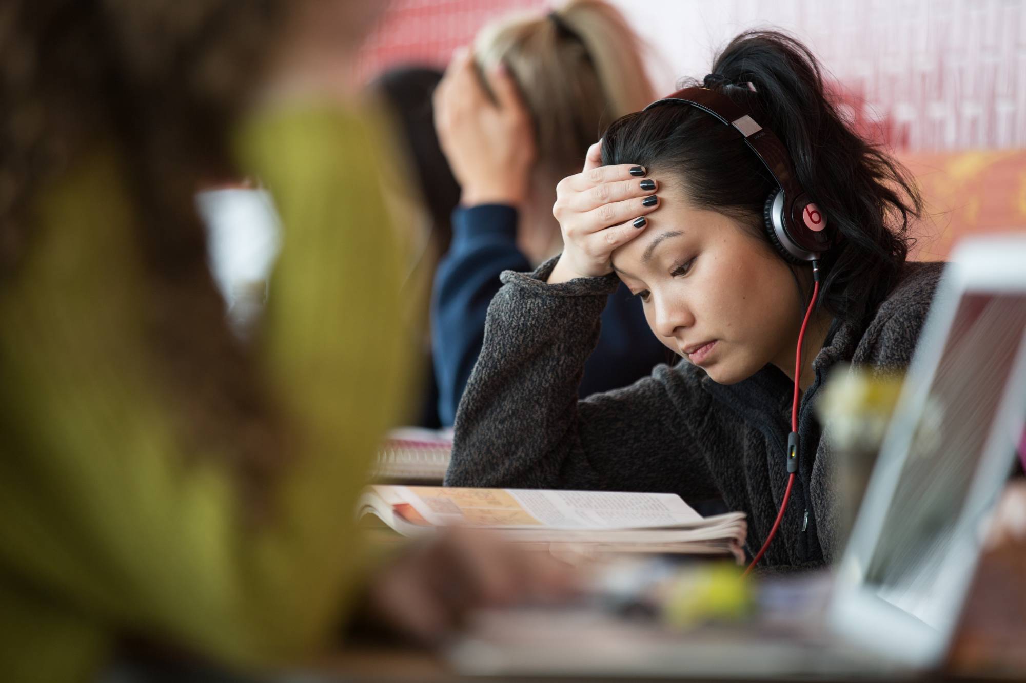 Female student engaged in reading textbook at library